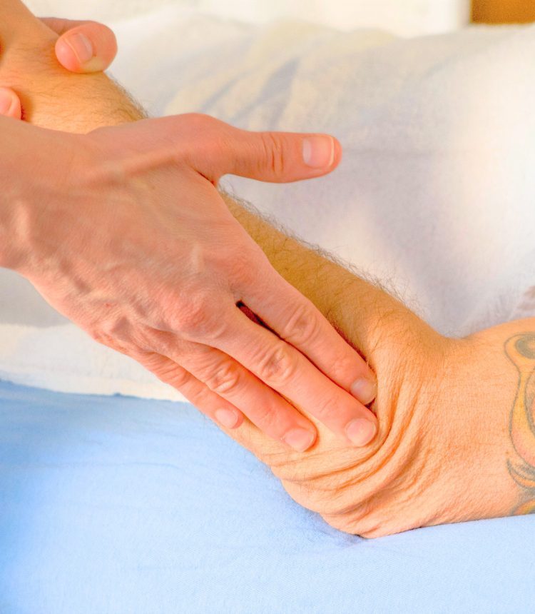 Terapista che esegue trazioni sul tessuto connettivo dell’avambraccio durante un trattamento a Lugano